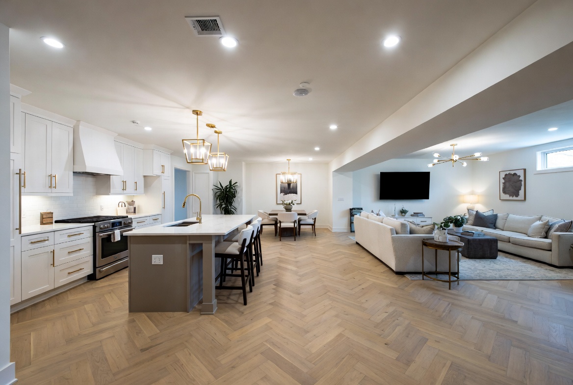 Renovated luxury kitchen — herringbone white oak floors, marble waterfall island