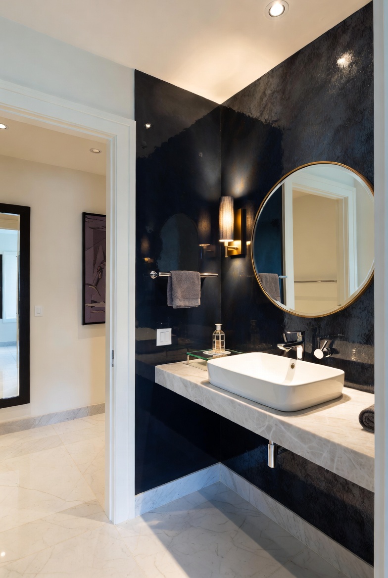 Powder room renovation — lacquered navy feature wall, marble vanity, vessel sink, brass mirror